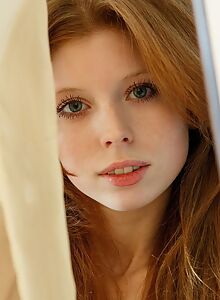 Cute redhead nude by a window