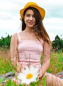 Cute brunette lifts up her dress in a field