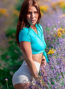 Athletic brunette stripping in a field
