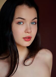 Black-haired cutie with blue eyes exposes her ass and pussy