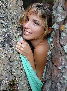 Lovely blonde with tan lines nude by a tree
