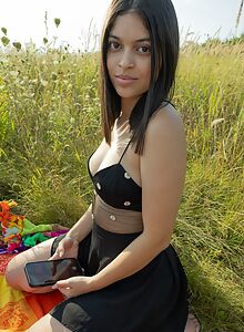 Curvy Latina stripping in a field