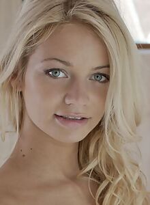 Shaved blue-eyed blonde nude in bed