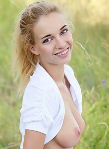 Hard-bodied blonde nude in a field