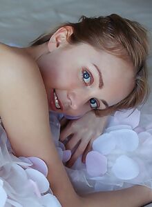 Blue-eyed blonde with pale skin spreading in bed