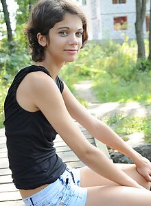 Black-haired teen spreading by a pond