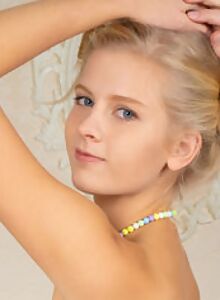 Blonde teen with blue eyes spreading on a chair