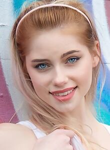 Blue-eyed blonde with pale skin lifts up her skirt