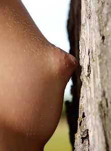 Skinny teen naked by a tree