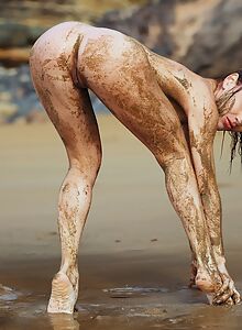 Sexy redhead spreading in the mud