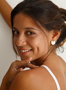 Freckled brunette with tan lines posing nude in bed
