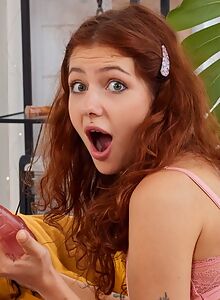 Cute shaved redhead toying her meaty pussy by a window