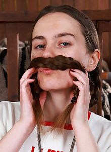 Long-haired brunette with small tits takes off her revealing jean shorts and spreads her hairy holes