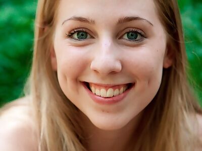 Sexy blonde with dimples stripping in a forest