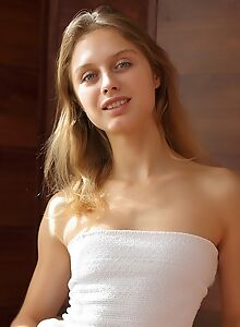Flat-chested blonde lifts up her dress in a chair