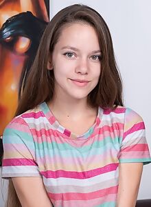 Cute brunette with long hair pulls down her jean shorts in bed