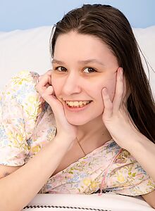 Cute brunette lifts up her dress and masturbates in bed