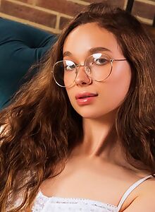 Shaved brunette takes off her lingerie on the couch