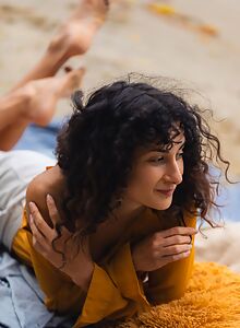 Shaved brunette plays with her big pussy lips at the beach