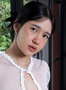 Cute Asian girl pulls her thong aside in bed