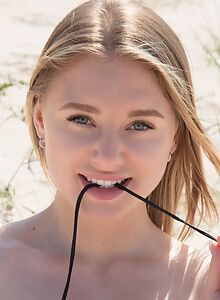 Cute shaved blonde takes off her bikini at the beach