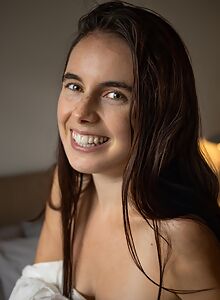 Freckled brunette exposes her asshole in bed