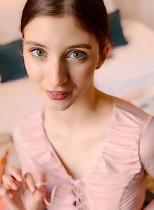 Cute shaved brunette exposes her pussy in bed