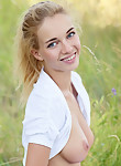 Hard-bodied blonde nude in a field