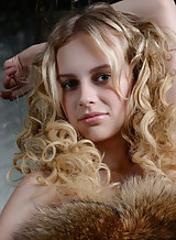 Curly-haired blonde with pale skin posing nude