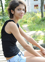 Black-haired teen spreading by a pond