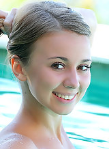 Cute blonde teen nude in a pool