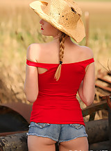 Blonde with pigtails stripping in a field