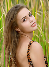 Sexy brunette teen nude in a field