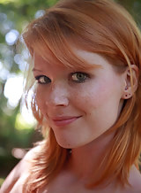 Freckled redhead Mia Sollis spreading in a forest